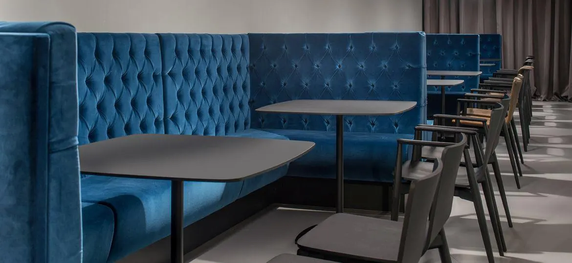 Panche con schienale capitonné in velluto blu in una sala da pranzo